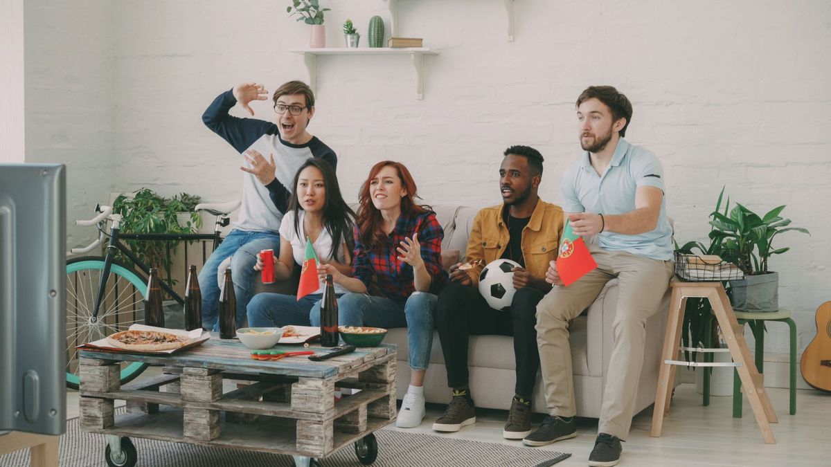 Friends cheering while watching sport at home