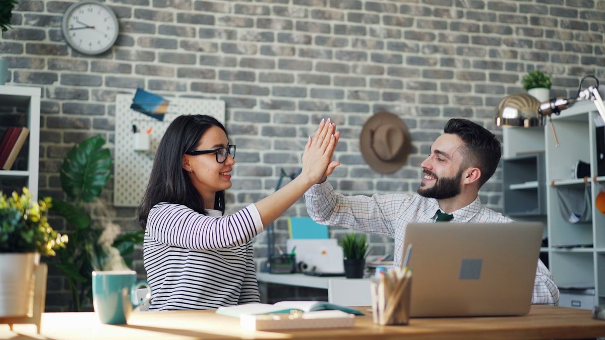 Colleagues celebrating at a desk